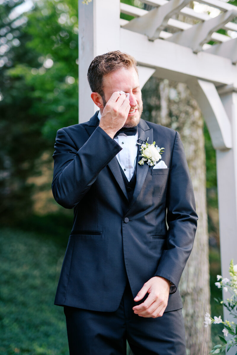 Groom holding a drink at cocktail hour at Glen Foerd Estate in Philadelphia, PA