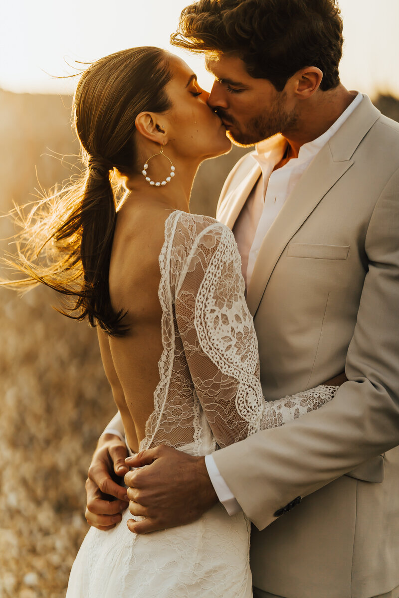 couple laughing holding hands in sand dunes