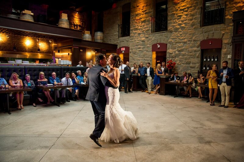 This joyful photograph captures the bride and groom sharing a dance at Murrieta's in Calgary, creating a beautiful and memorable moment on their wedding day.