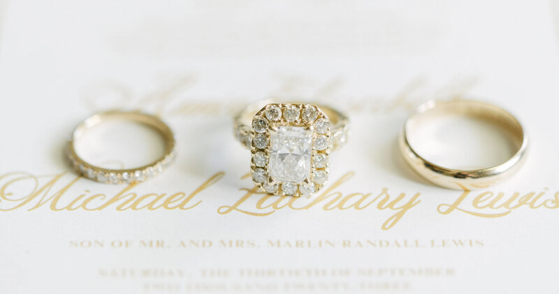wedding rings laying on top of wedding stationery