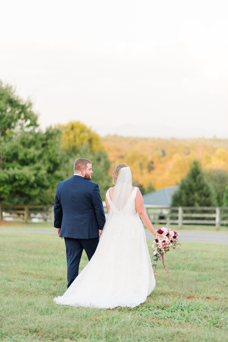 bride and groom walking into sunset together