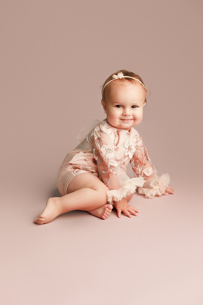 Baby surrounded by boho props in warm-toned milestone session