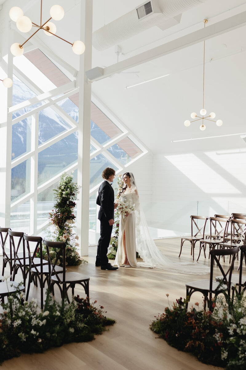 Wedding planner setting an elegant reception table with florals, candles, and gold flatware — showcasing professional wedding planning services in Canmore.