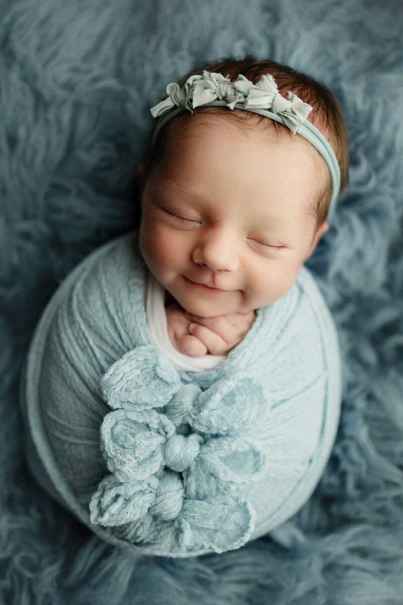 Fort Collins newborn girl wrapped up with 3 bows tied in