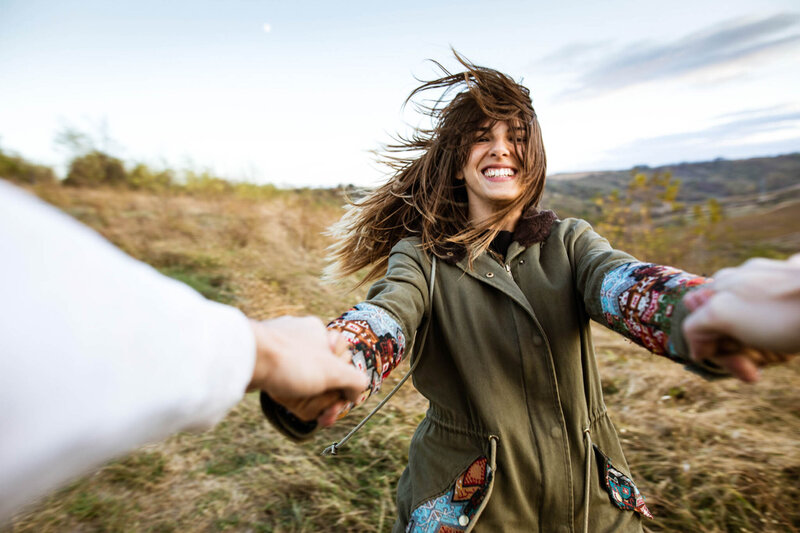 iStock-1189715099 Cheerful woman having fun while spinning with her boyfriend in nature.