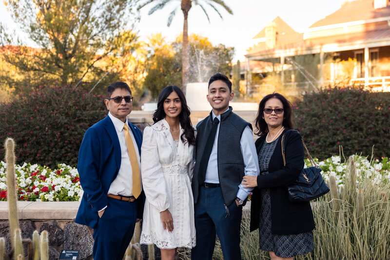 family smiling with graduating daughter