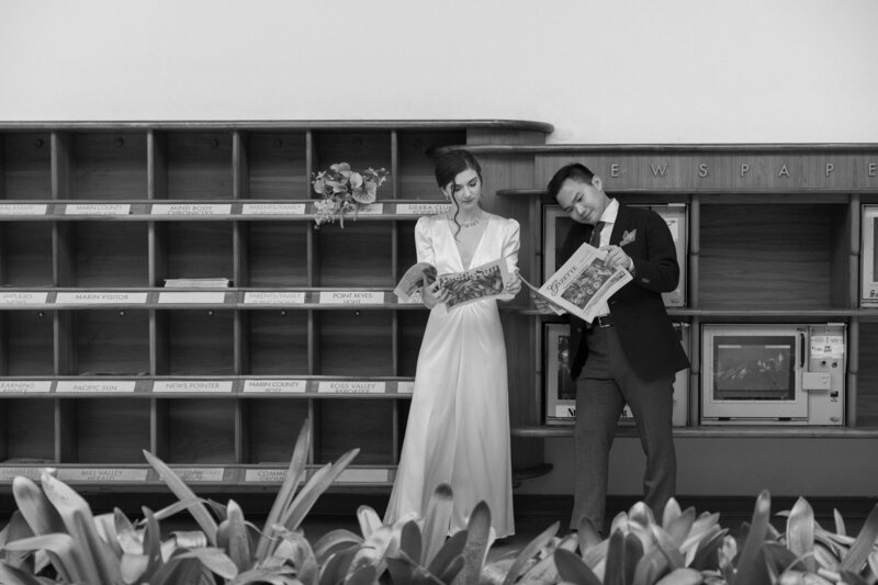 Black and white photo of couple holding newspapers in Civic Center.