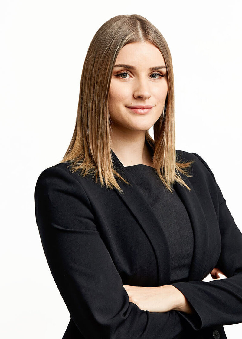 Confident corporate woman with arms' crossed against white background.