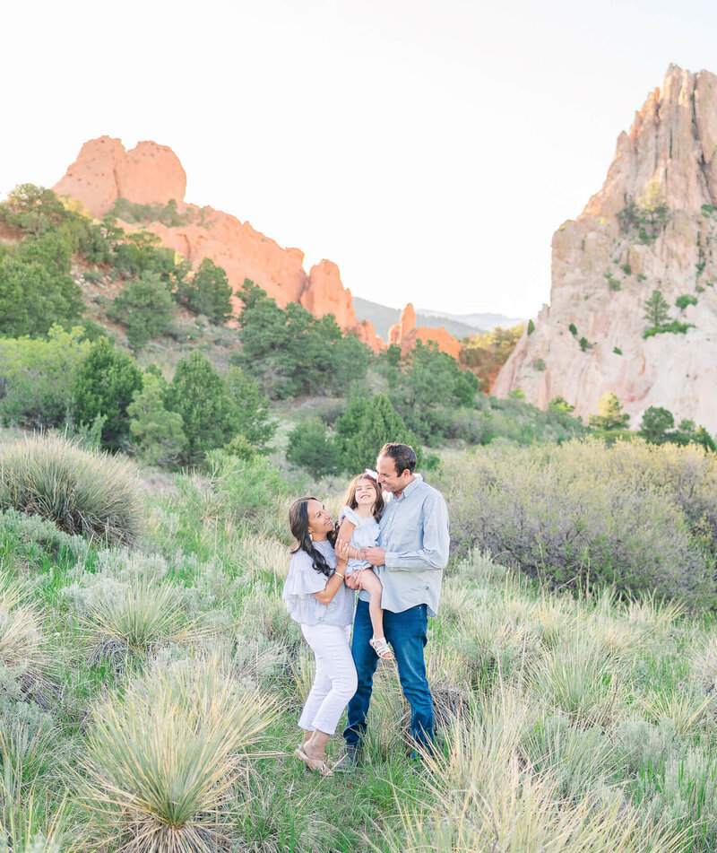 A family of three standing in a yucca field in Garden of the Gods park in Colorado Springs for their family photos.