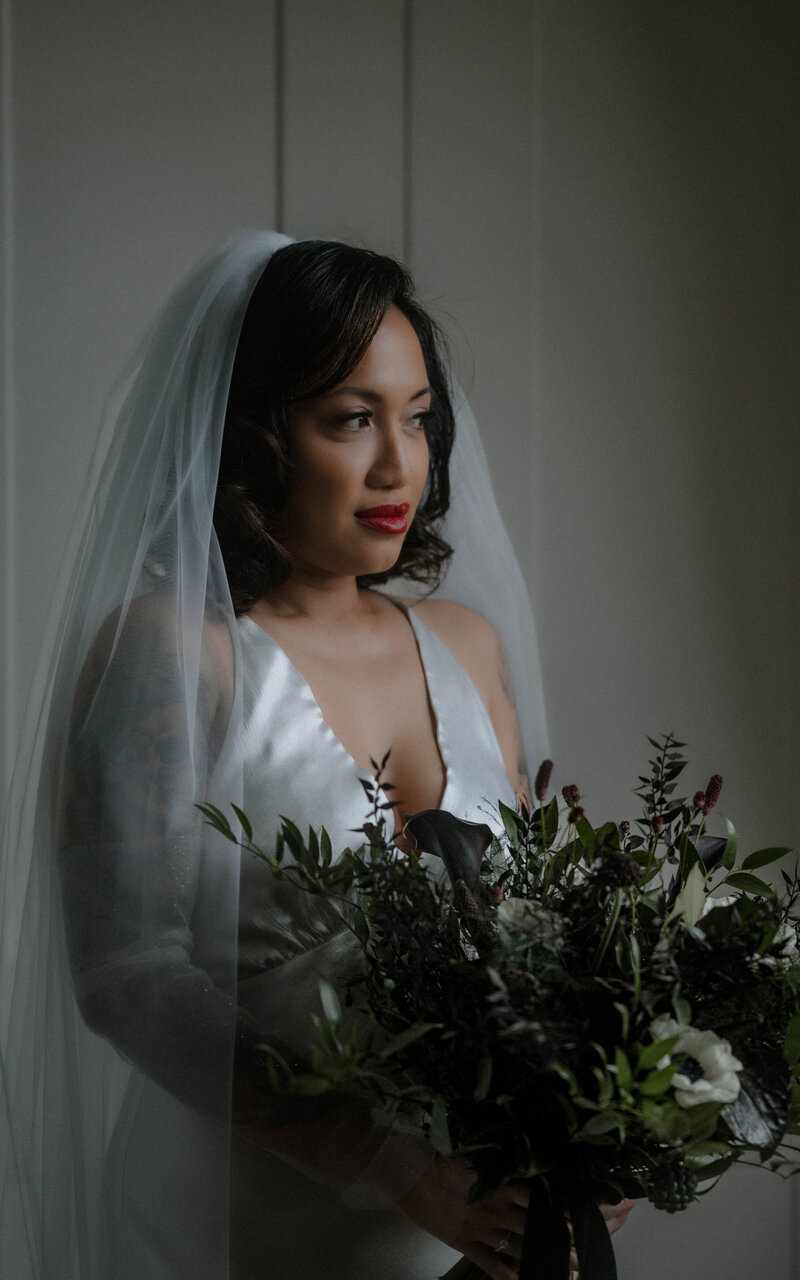A stunning bride holding her bouquet, radiating elegance and beauty as she prepares for her special day, surrounded by love and anticipation
