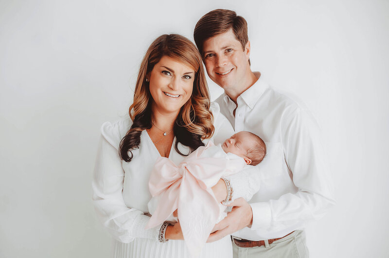 New parents embrace their baby during Newborn Photoshoot in Charleston, SC.