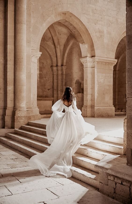 Bride running through beautiful arches in Europe during elopement