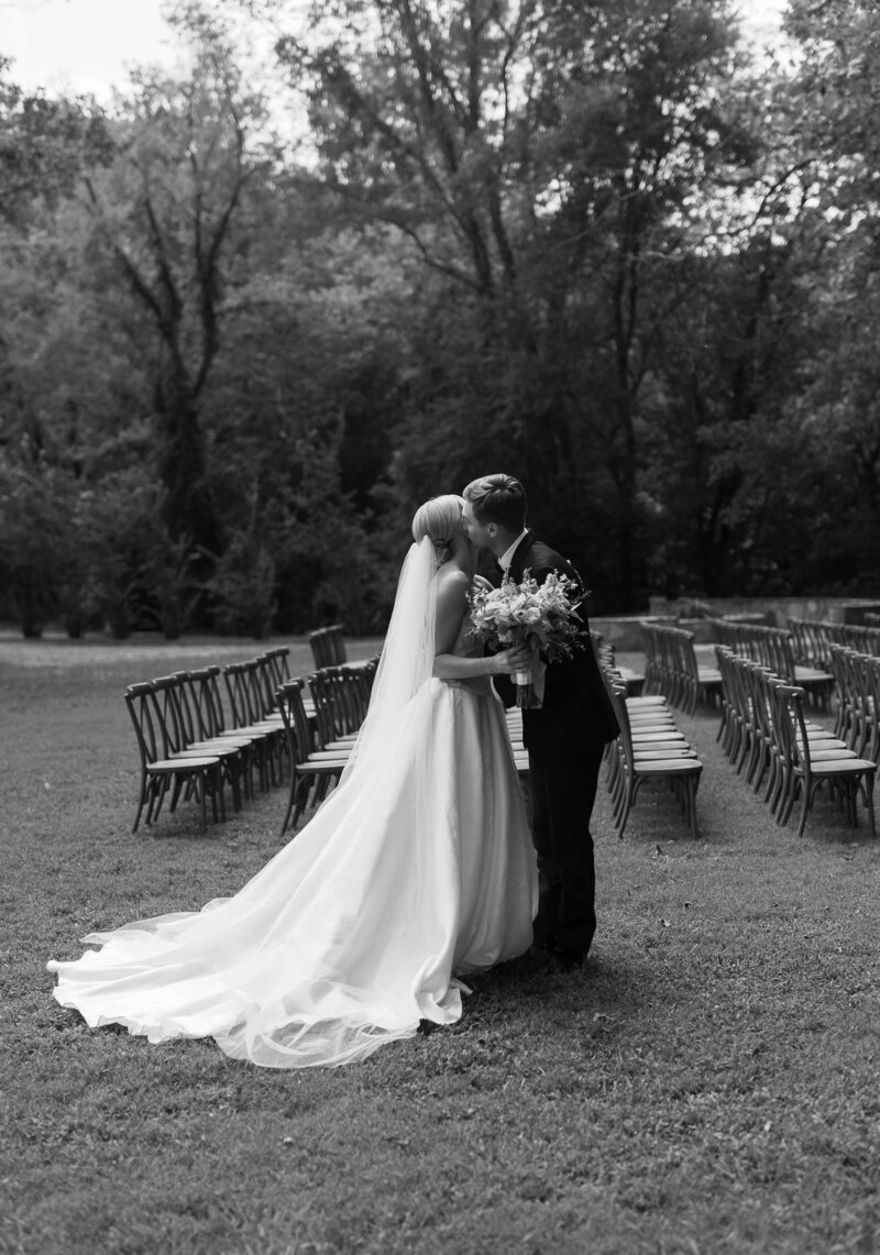 Groom kissing his bride on the cheek during their first look and vows.