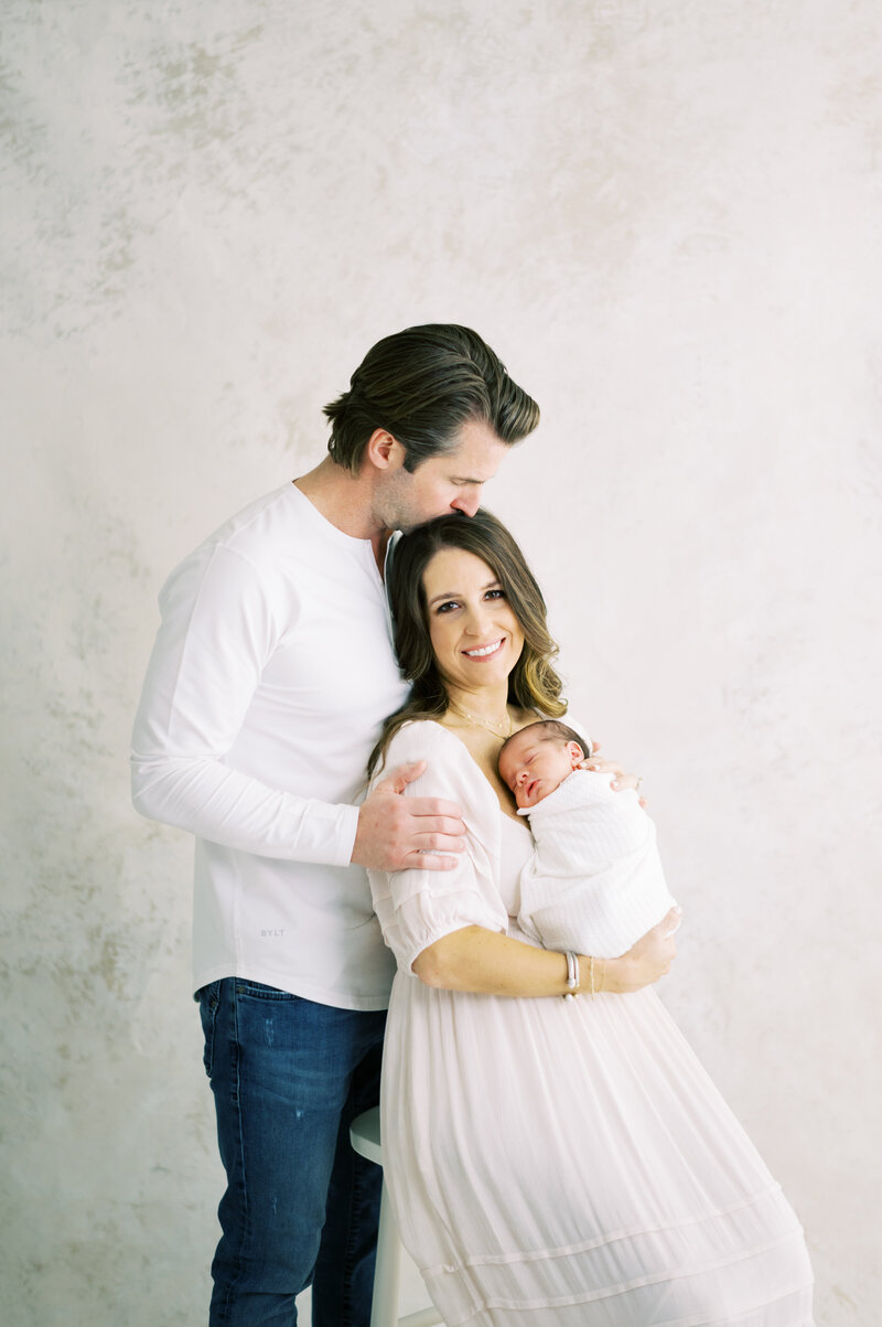 Newborn being held by mom and dad in Nashville photography studio