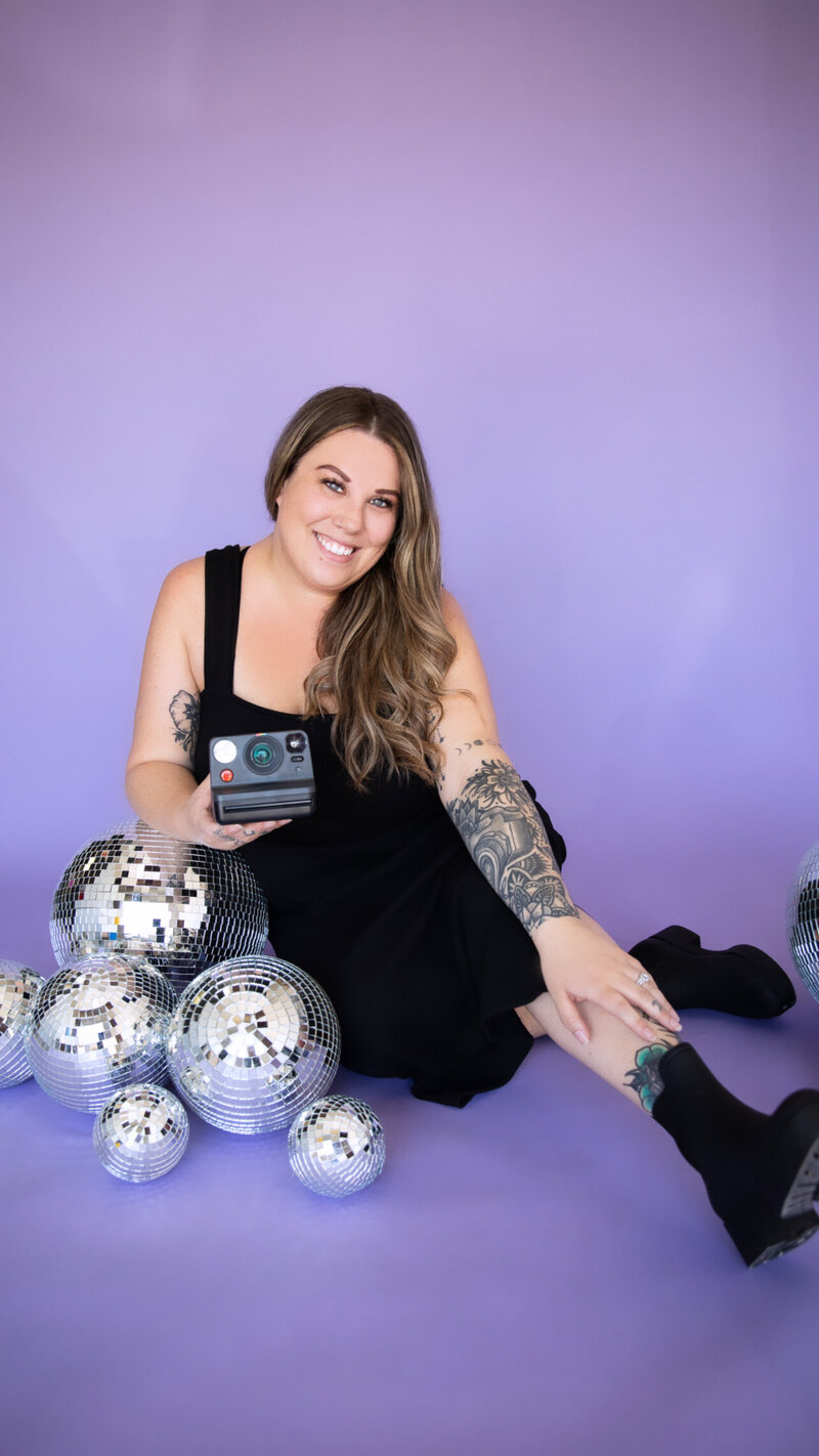 A woman posing with disco balls in an Austin photo studio.