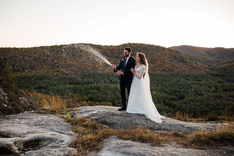 A couple celebrates on a mountain top after their ceremony