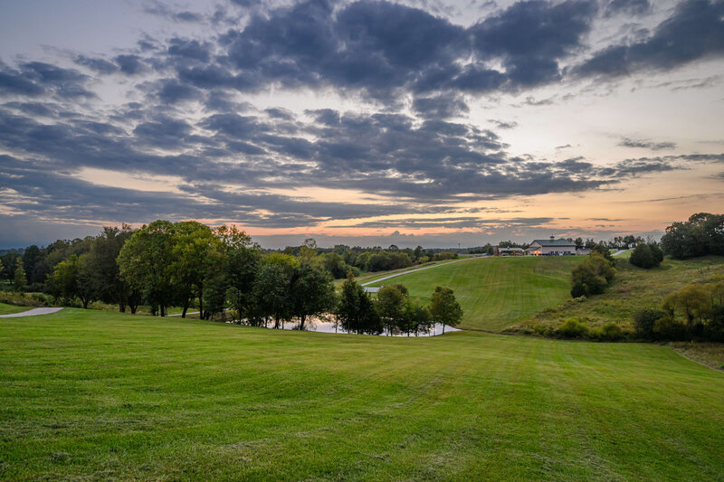 Expansive sunset view of the rolling hills and serene pond at Willow and Stone Events in Mocksville, NC.