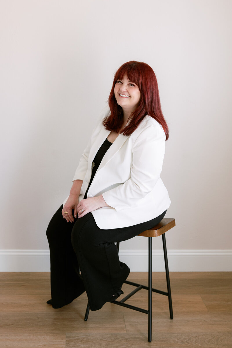 Anna Delores Photography founder, Emily, smiles in a green and navy dress