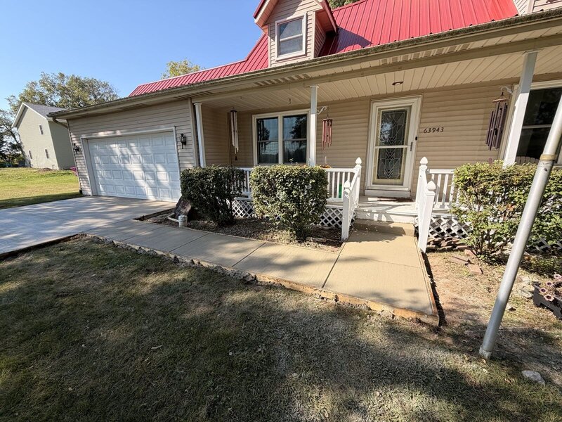 New concrete driveway and front walk at a red-roof farmhouse in Goshen, IN