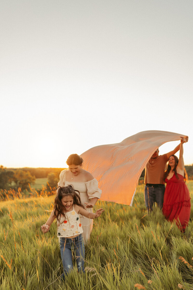 Family playing in an Ames field at sunset.