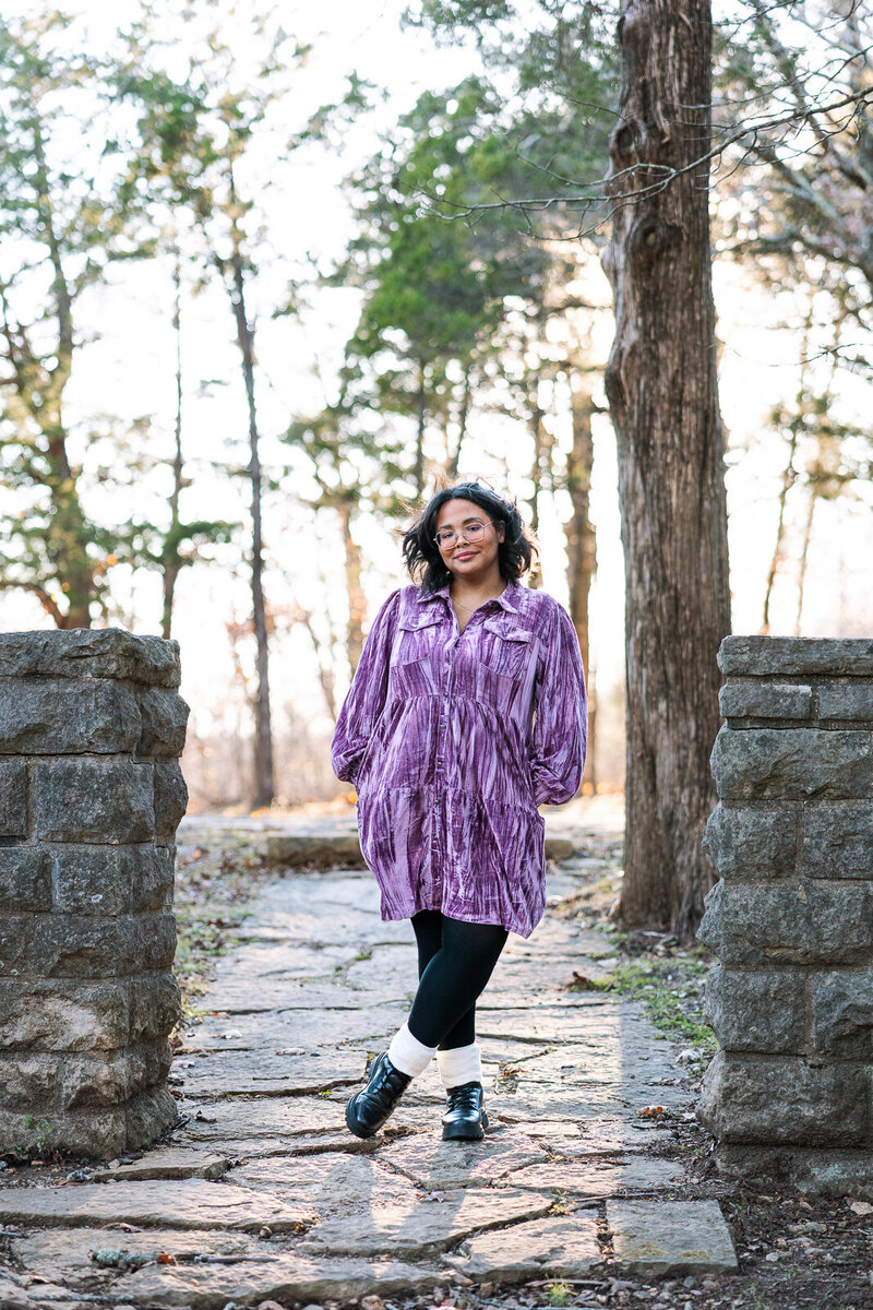Senior girl standing next to stone fence in De Soto, Missouri. 