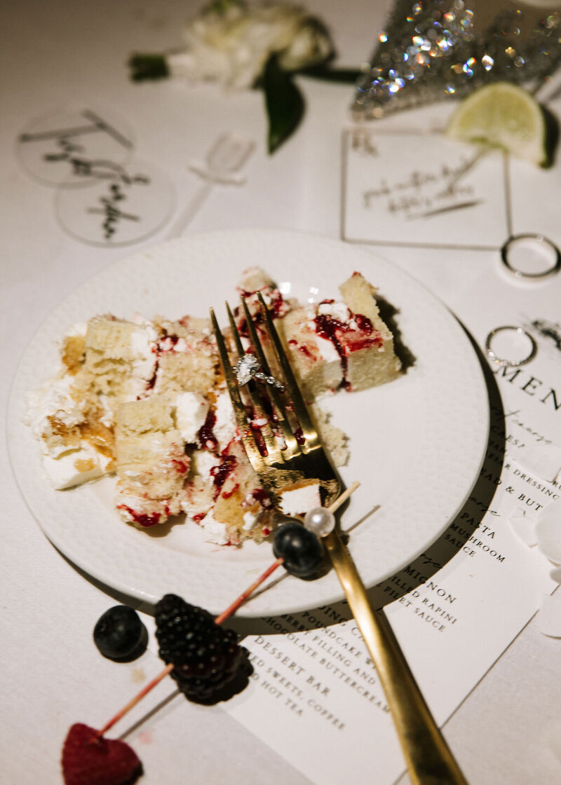 Wedding cake on plate with wedding details - rings, menu, 