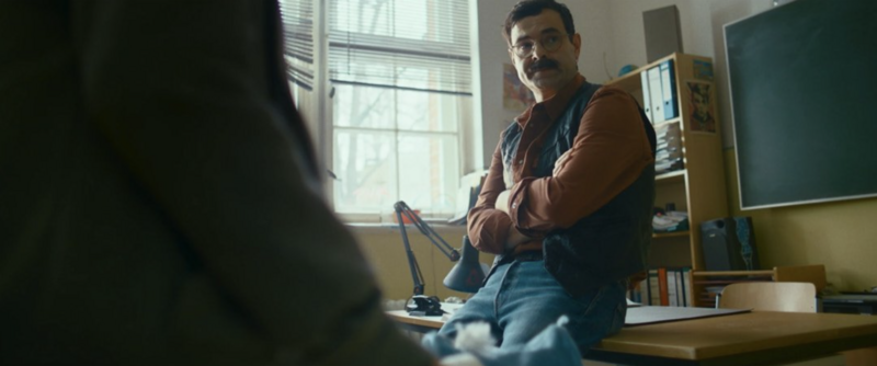 A transition scene where a young character looks out of a bus window in thought.