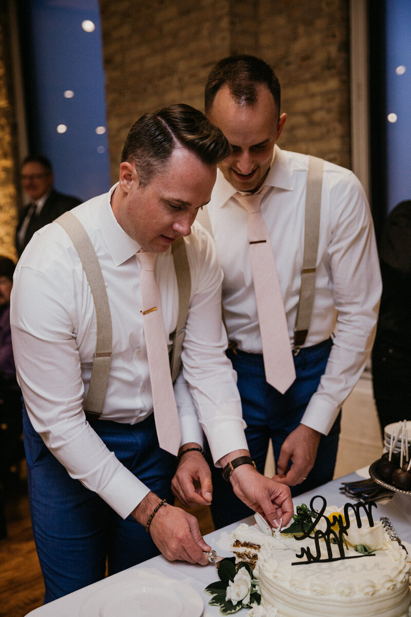 reception cake cutting with two grooms