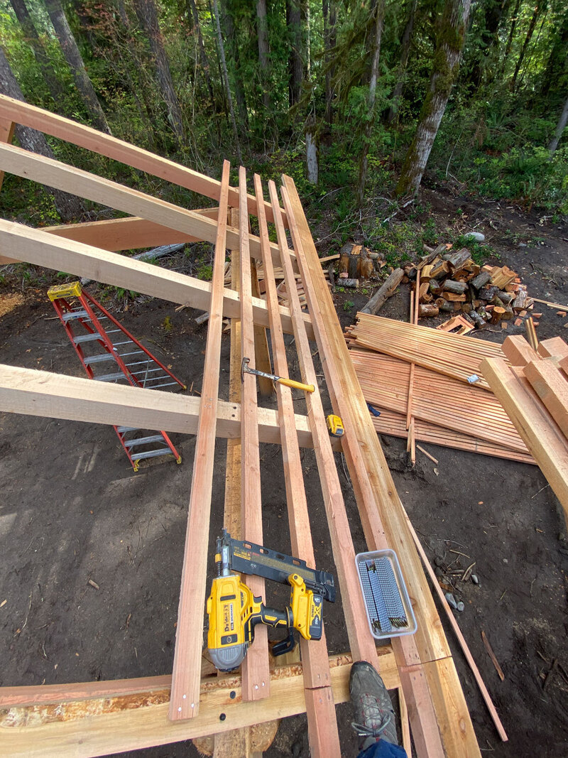 Overhead view of wooden pavilion roof construction with tools and materials