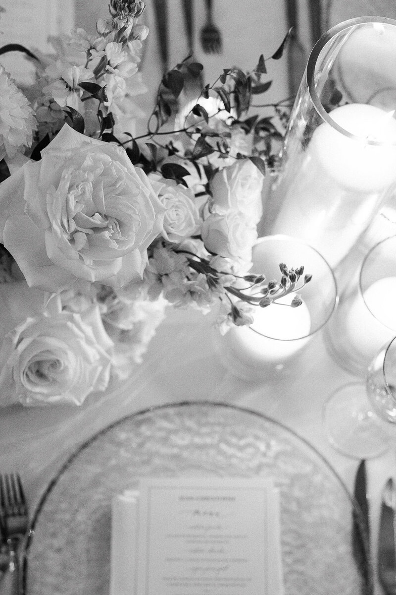 Détails sur une table lors d'une réception de mariage, image en noir et blanc, fleurs blanches. 