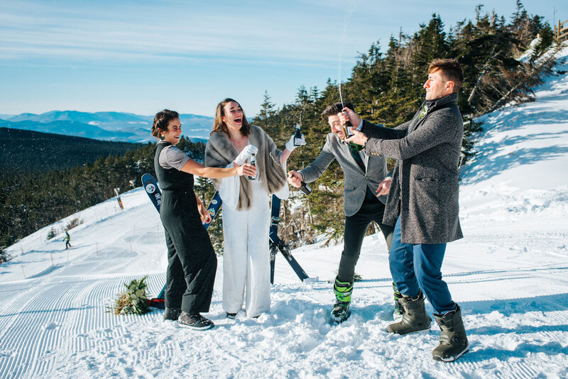 couple popping champagne elopement on skis killington vermont mountain