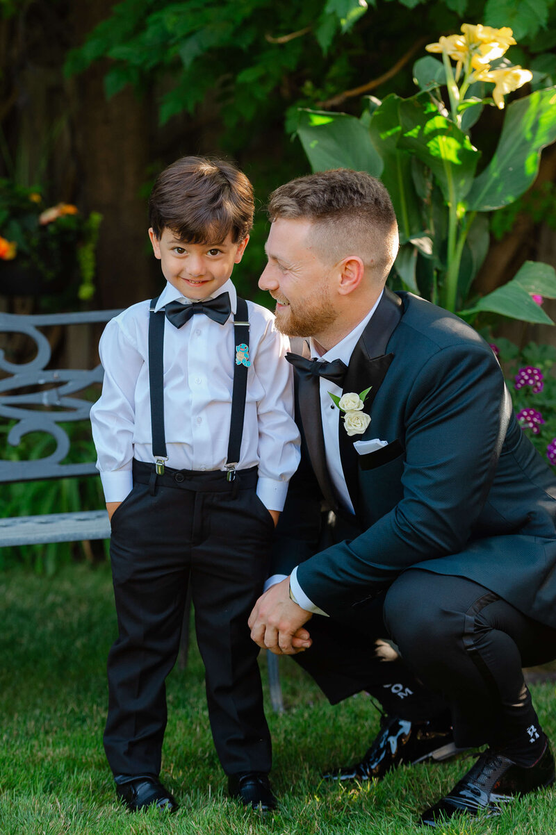 a groom bending down and smiling with ring boy.  Ottawa wedding photography by JEMMAN Photography