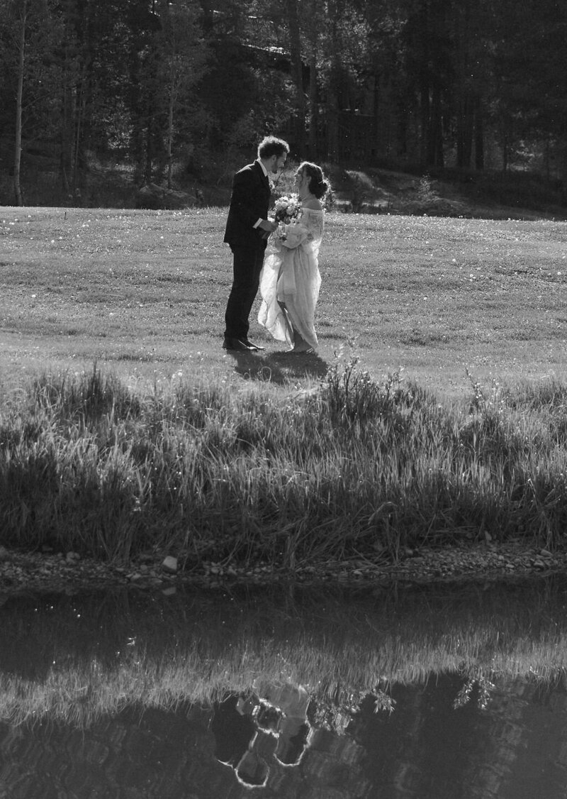 Black and white candid wedding photo of bride and groom sharing a quiet moment alone after their Camp Hale wedding ceremony in the mountains