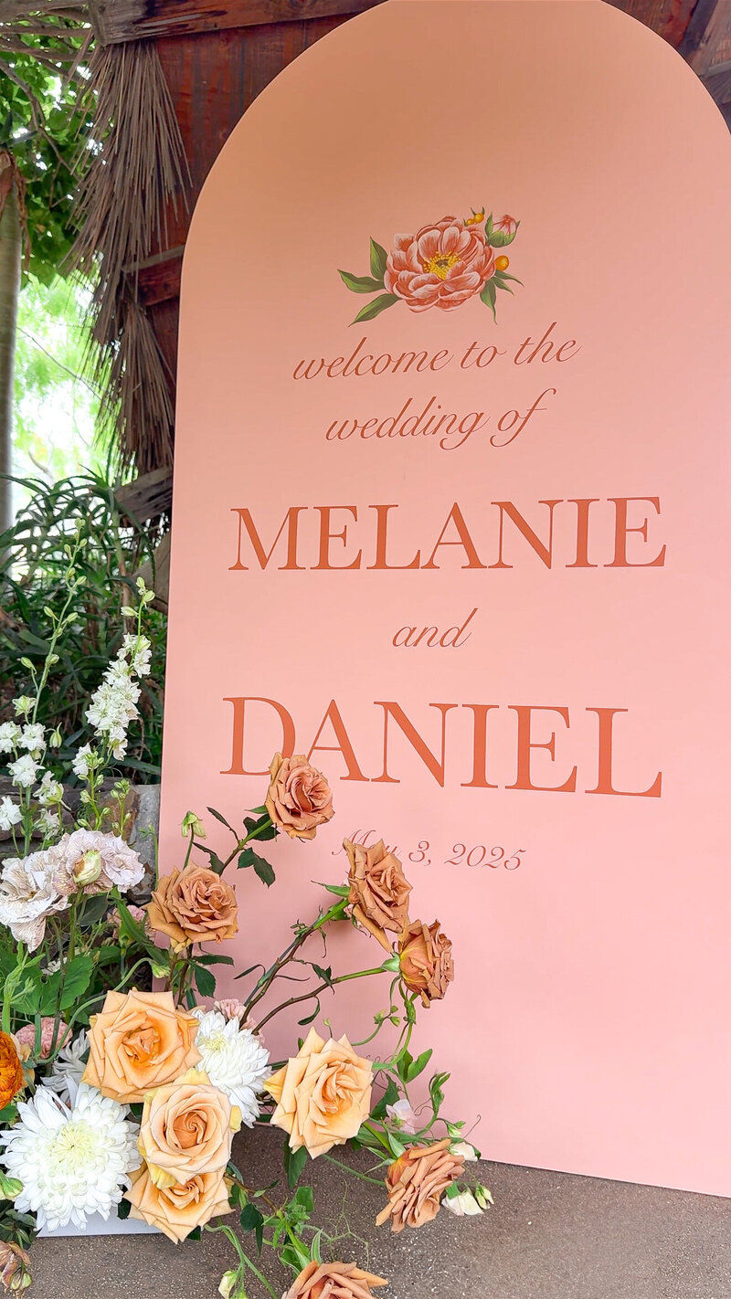 Large welcome sign in coral pink with florals surrounding it at San Diego Safari Park San Diego Zoo Safari Park.