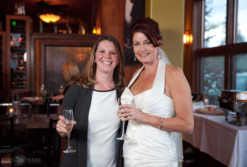 Bride gets a candid photo with her friend at the 5th Ave Grill in Frisco Colorao
