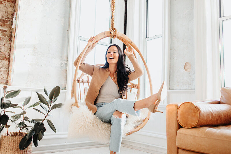 kat smiling in chair with leg up