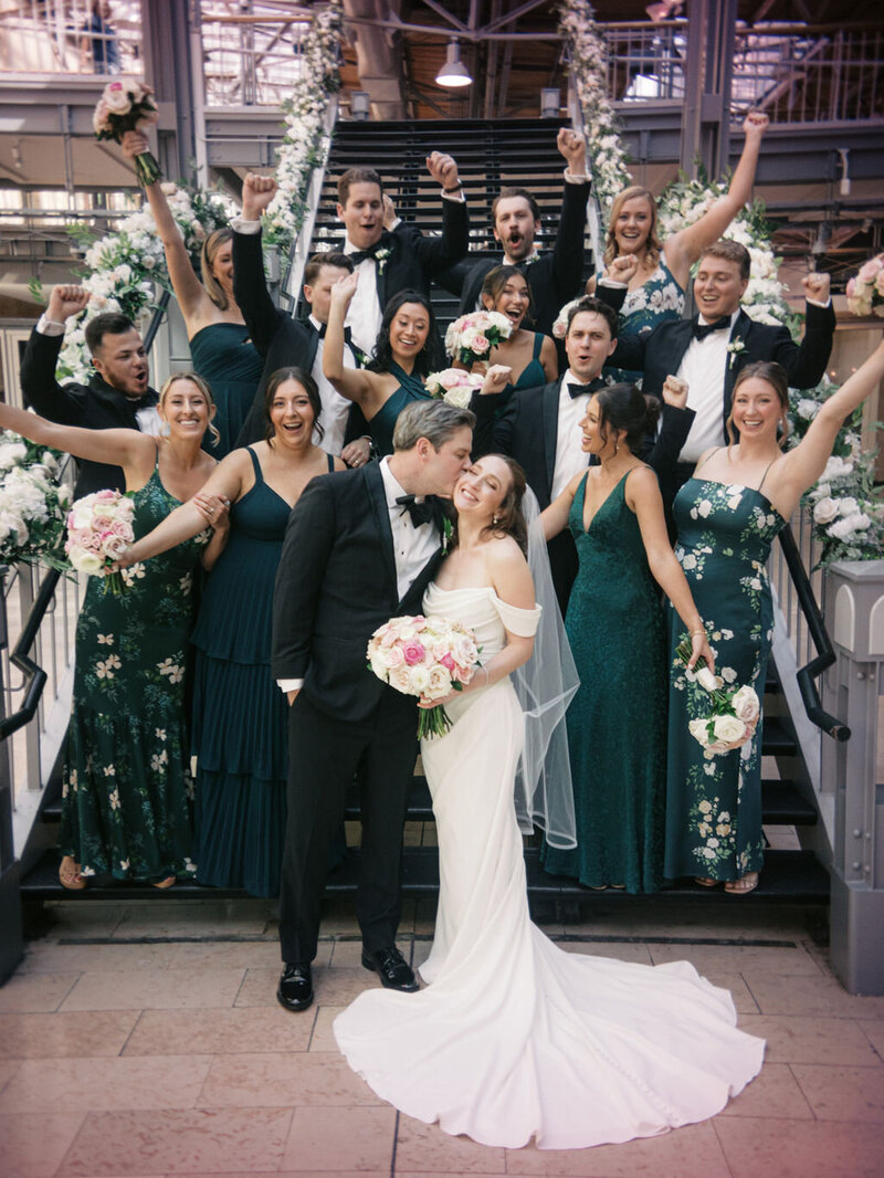 wedding party cheers as bride and groom kiss at Union Station St Louis