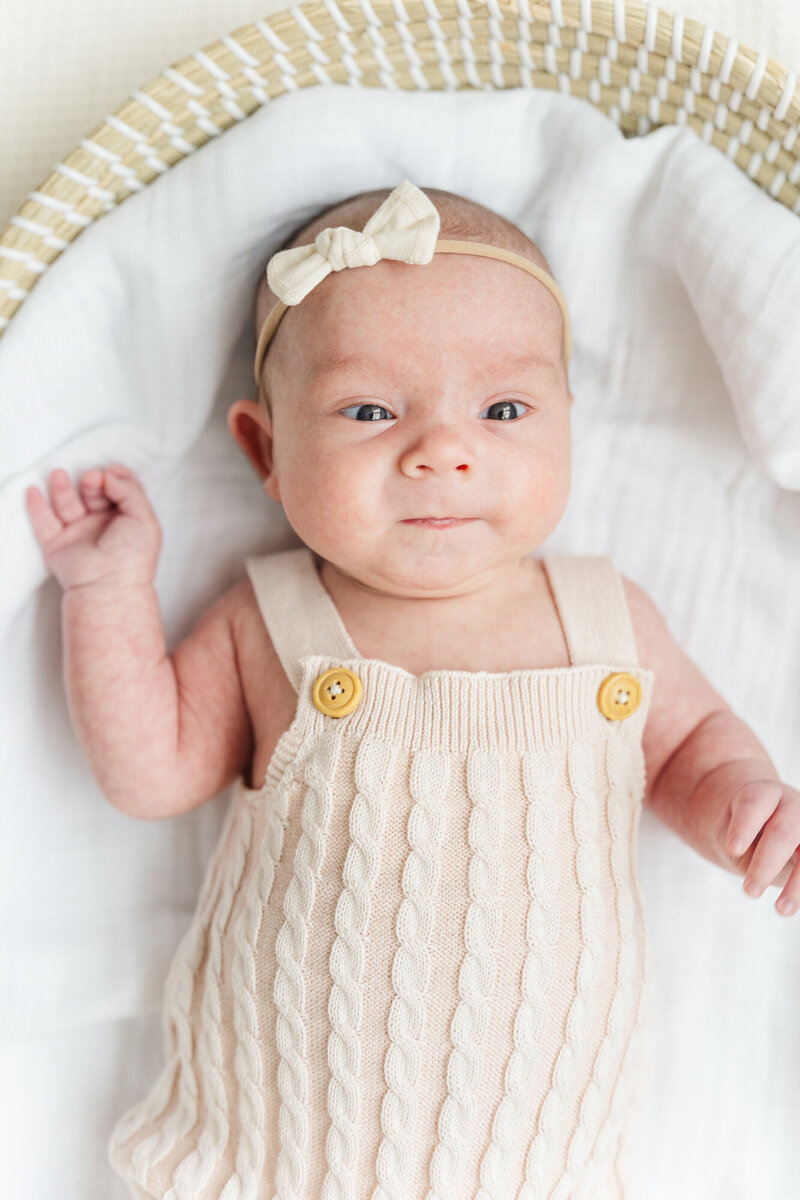 sweet sleeping newborn in a gorgeous little outfit being held by her mom