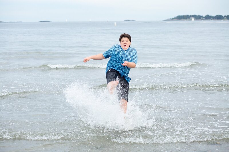 teenage boy splashing in ocean