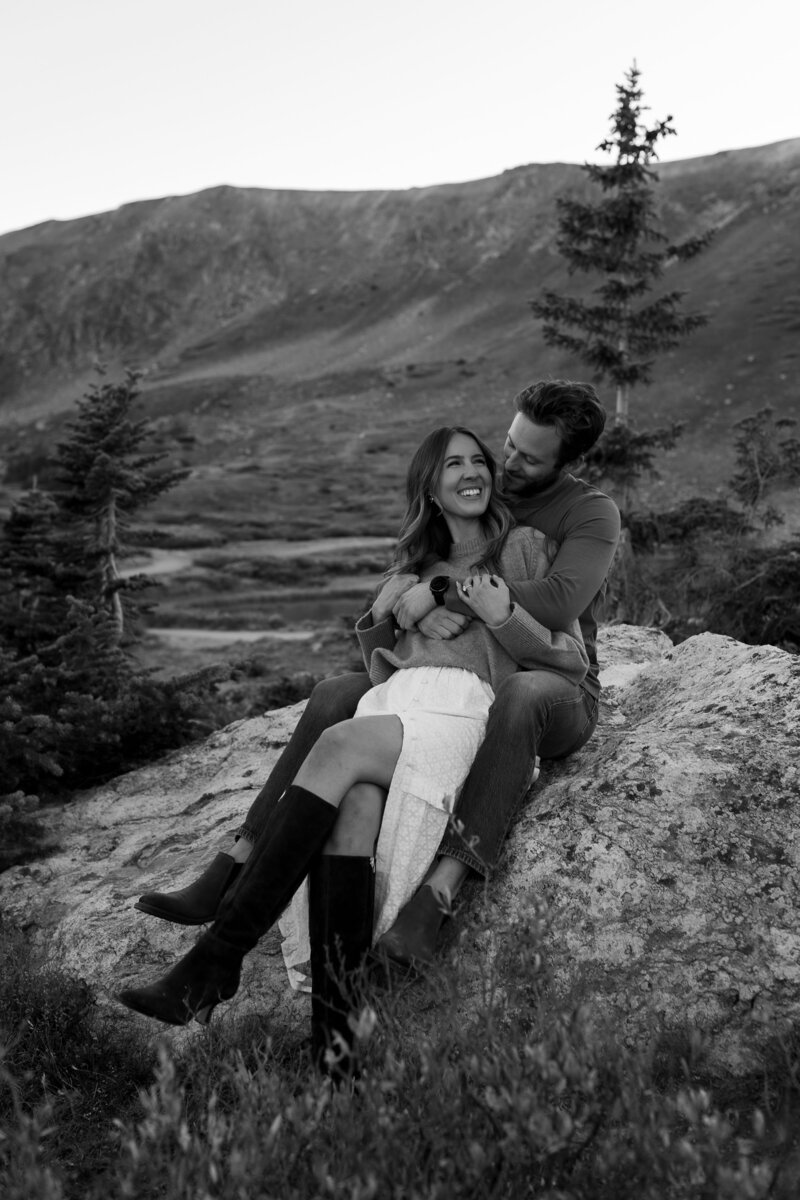 couple sitting in front of home in the mountains