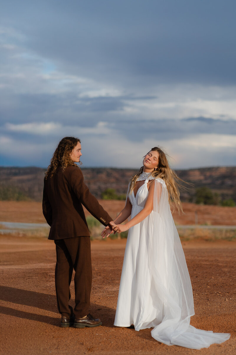 Couple exchanging vows at sunrise with Enchanted Rock and Turkey Peak rising behind them during intimate elopement