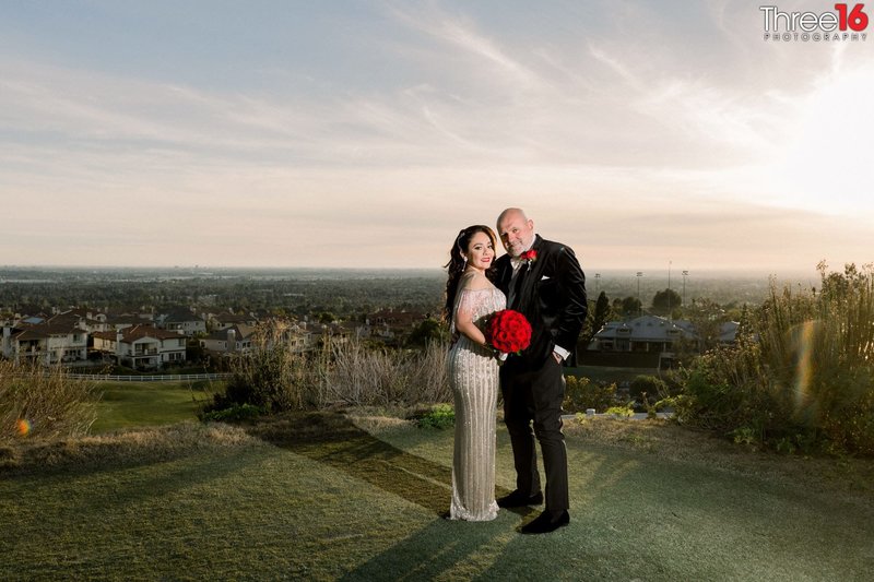 Bride and Groom pose together near sunset with the City of Yorba Linda below in the distance