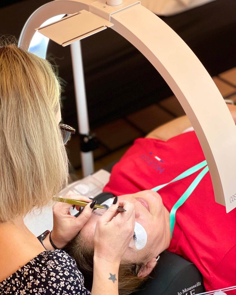 A lash technician working on a lash extension