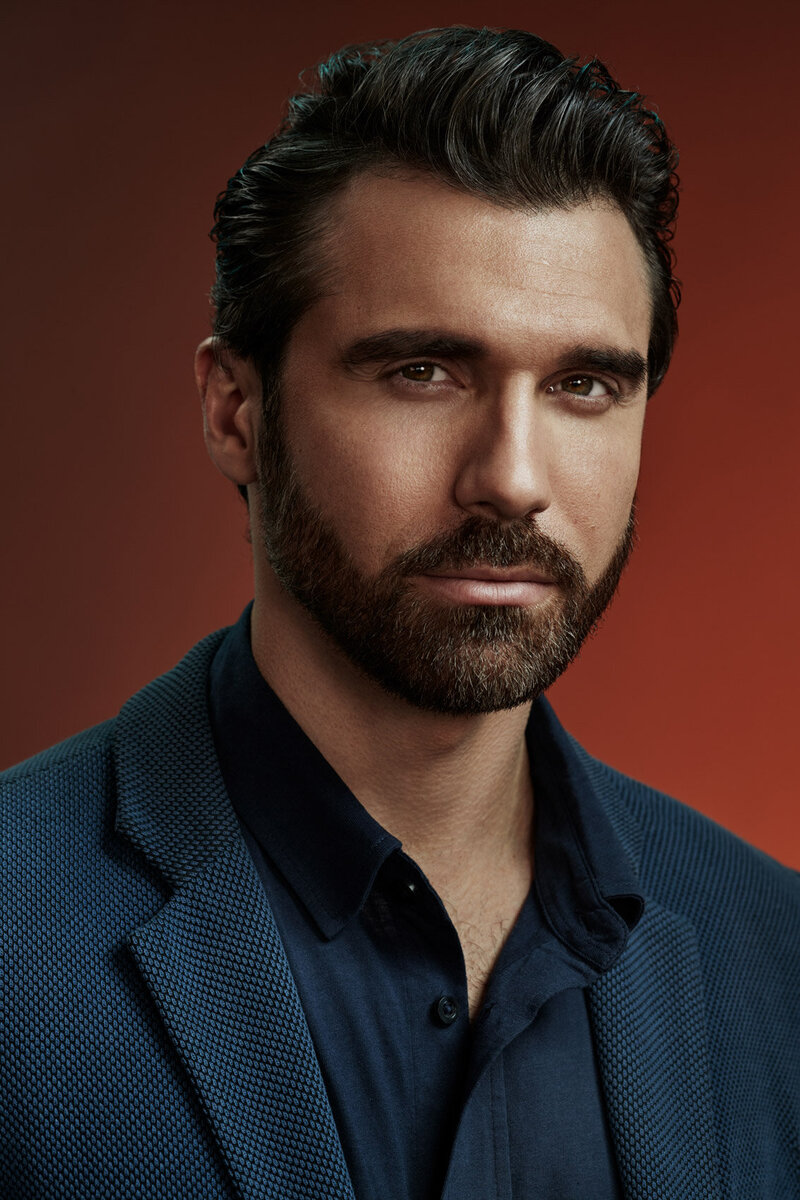 Formal portrait of Gamzat Lu in a blue suit, exuding confidence, captured by Ylva Erevall.