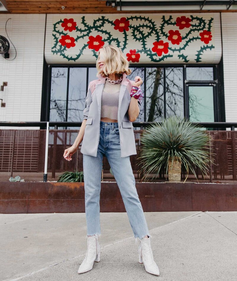 Charla Corn Barrett Posing looking to the left off camera, wearing fun fashionable outfit in front of floral mural | Charisma Coach for Successful Women