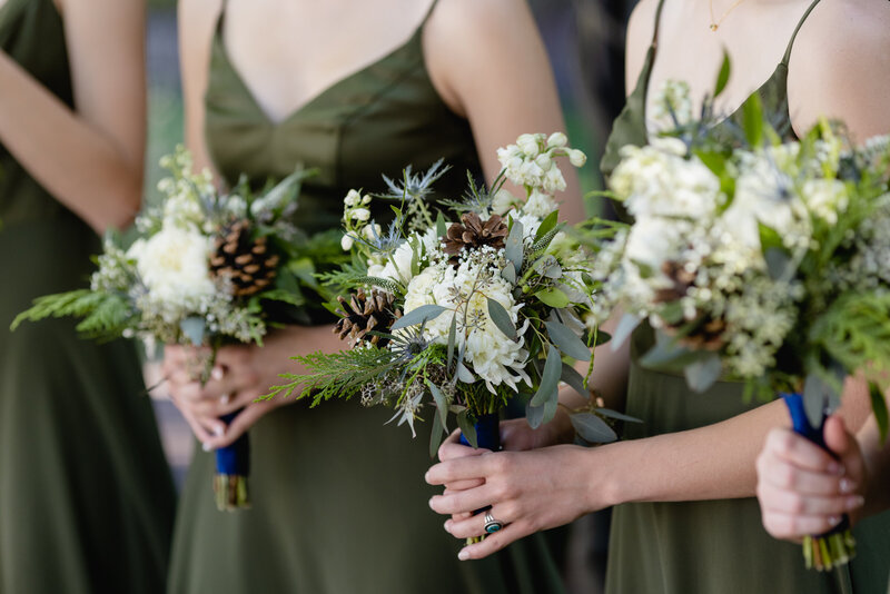 Bridesmaids stand holding bouquets