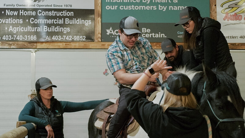 Facilitators guiding a man during his Therapeutic Riding session at Spirit's Respite Ranch in Red Deer, Alberta