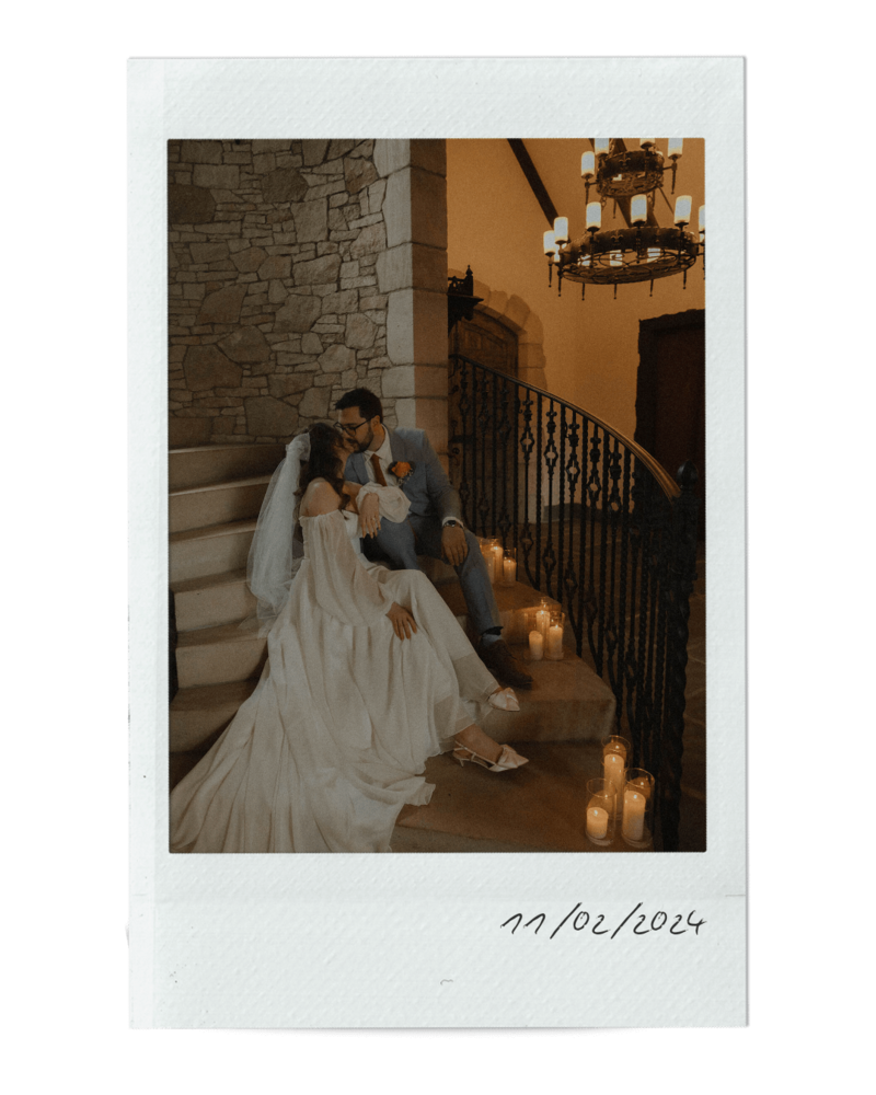 A polaroid picture of a bride and groom sitting on a stone stairway and kissing, representing a wedding in the event planning portfolio of Birdie June Events.