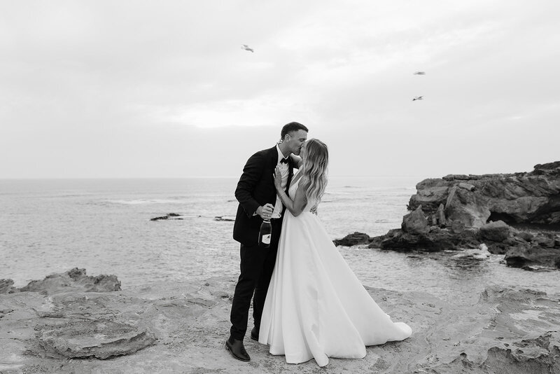 care free couple on their wedding day sharing a kiss at Thunder Point Warrnambool overlooking the ocean