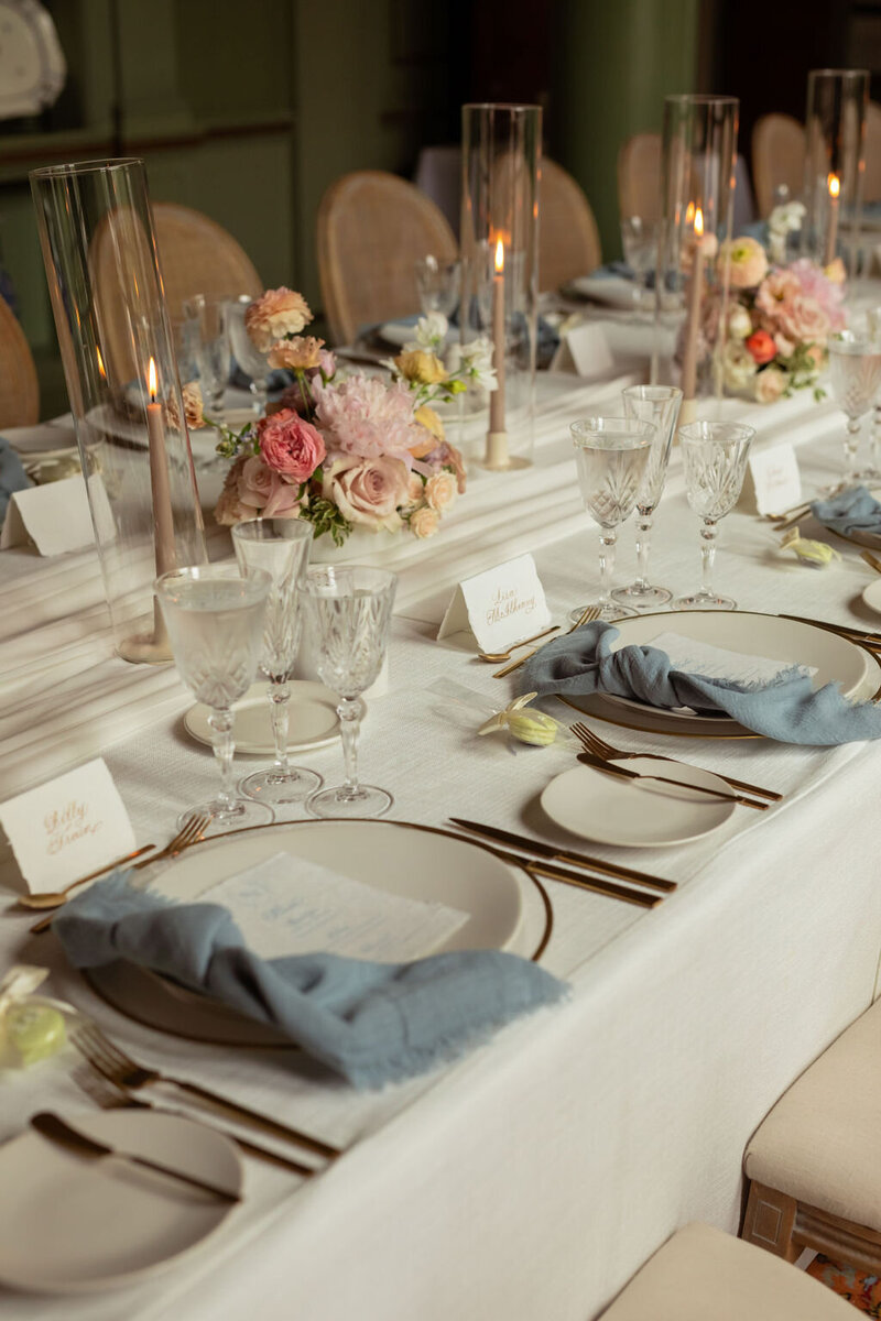 wedding dinner reception table with blue npakins and colotful florals